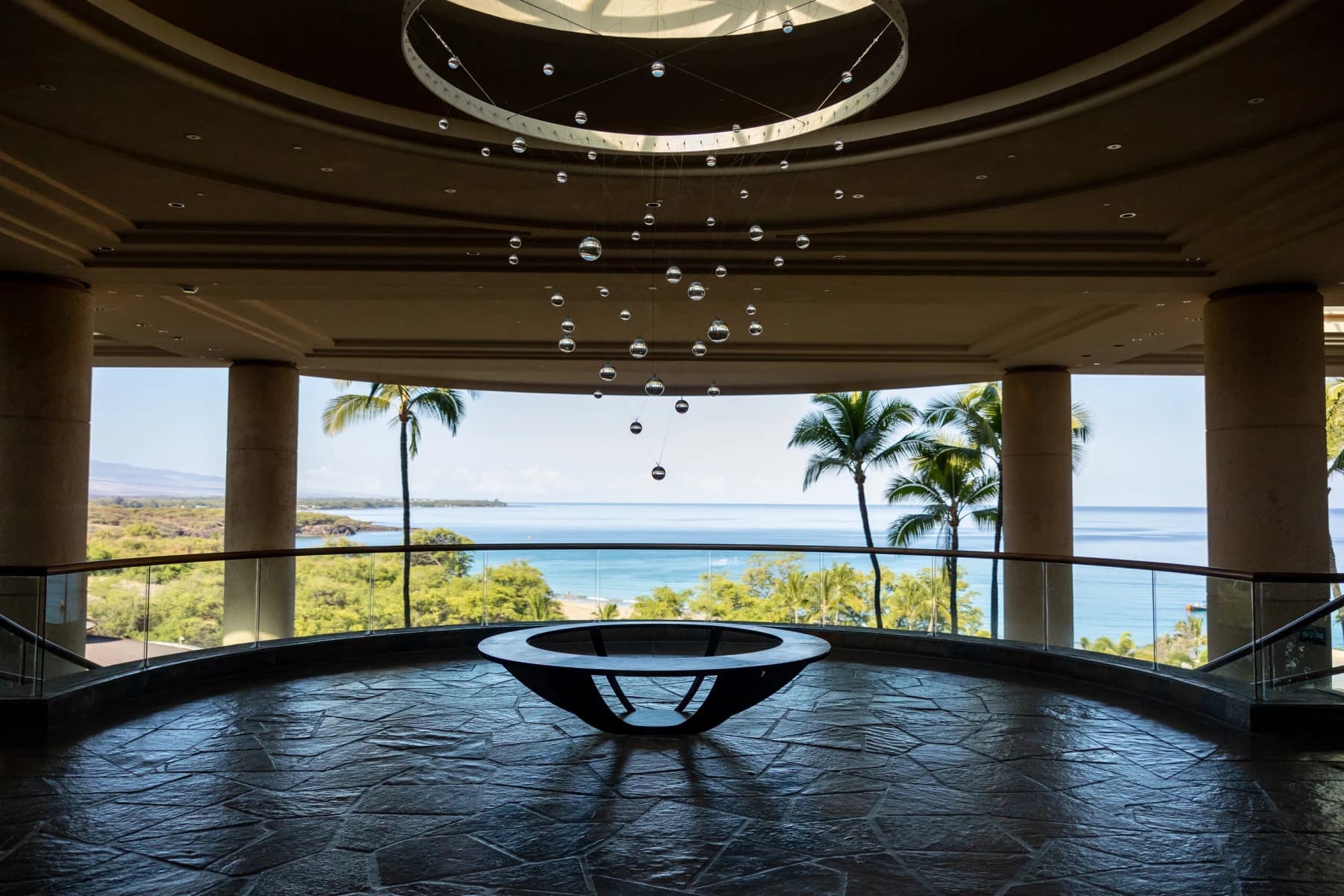 Salotto di lusso dal soffitto curvo con vetrate a tutta altezza e vista mare
